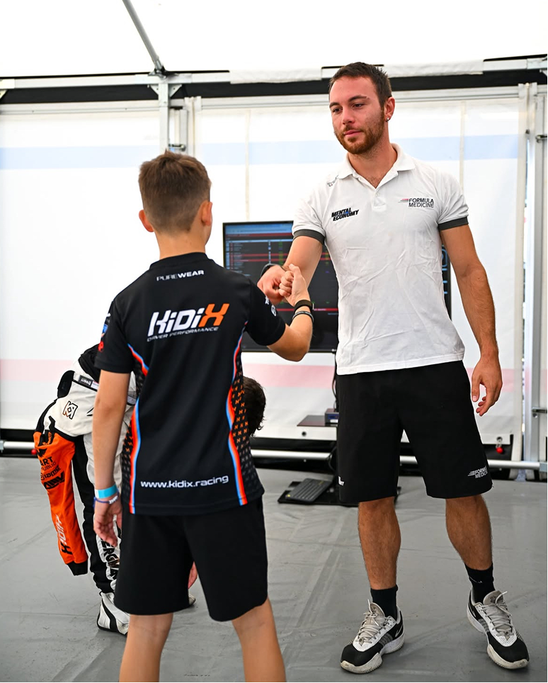 Andrea Tortorella encouraging a young kart driver during a performance training session